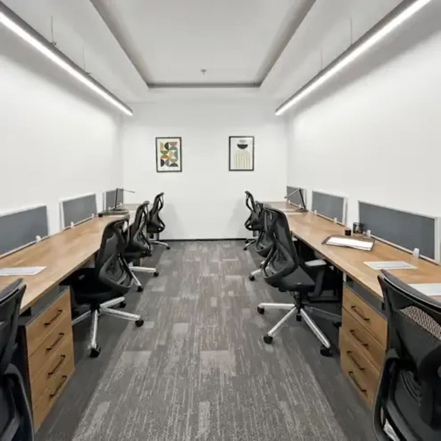 Sleek coworking area with ergonomic chairs and ample desk space, ideal for focused work.