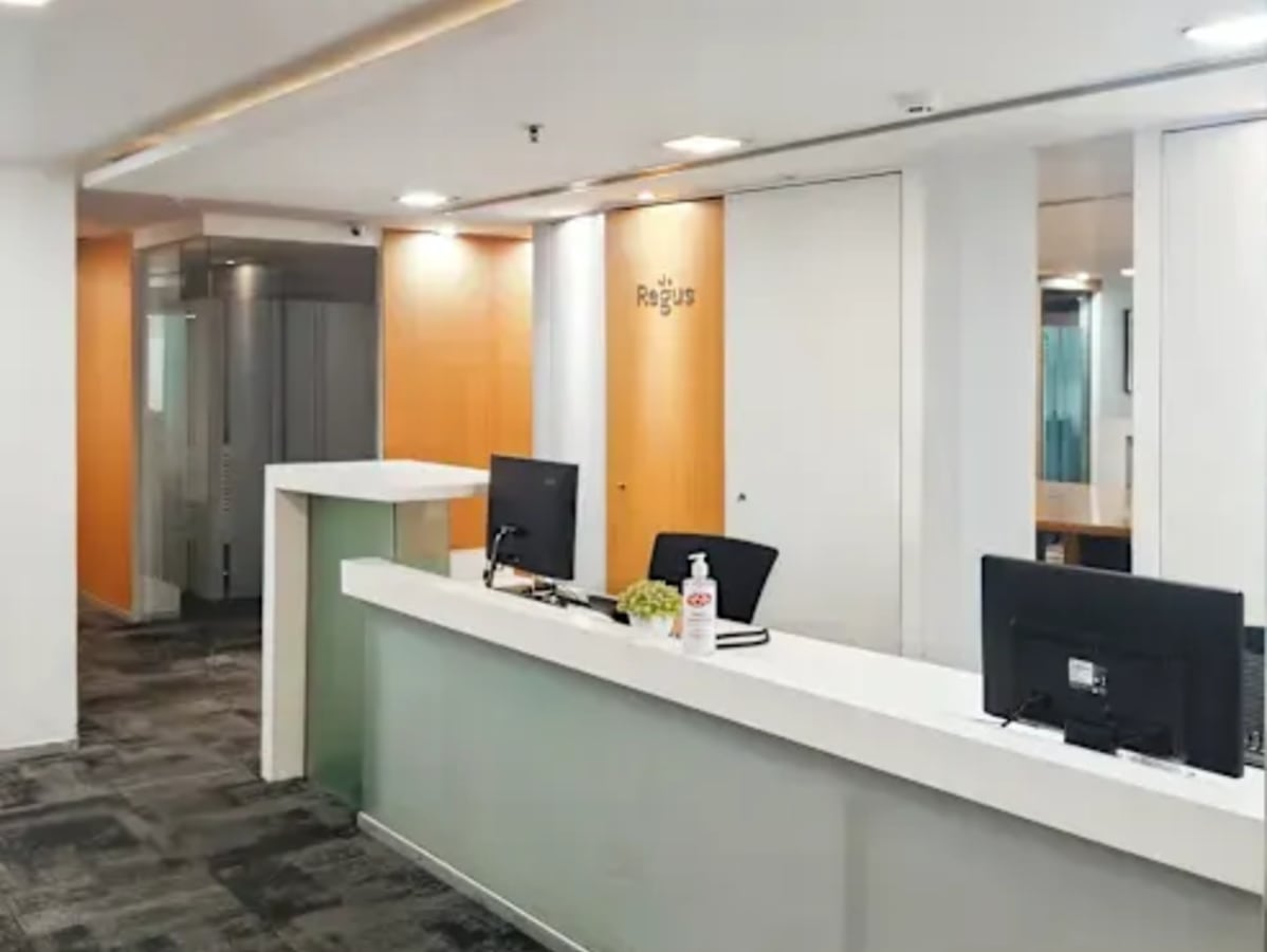 Modern coworking space with sleek desks, ample lighting, and a welcoming reception area.