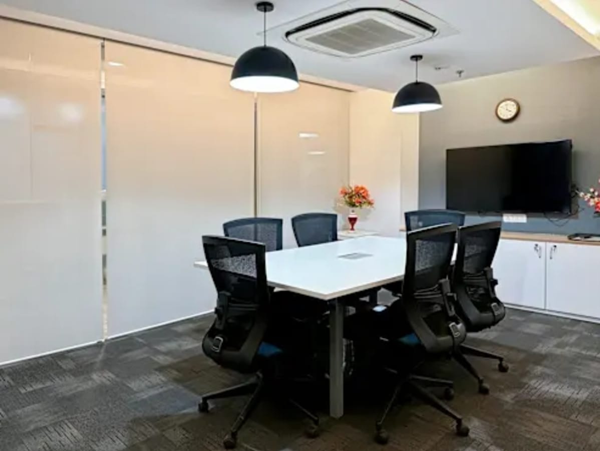 Modern meeting room in Gomti Nagar coworking space with sleek chairs and a large screen display.