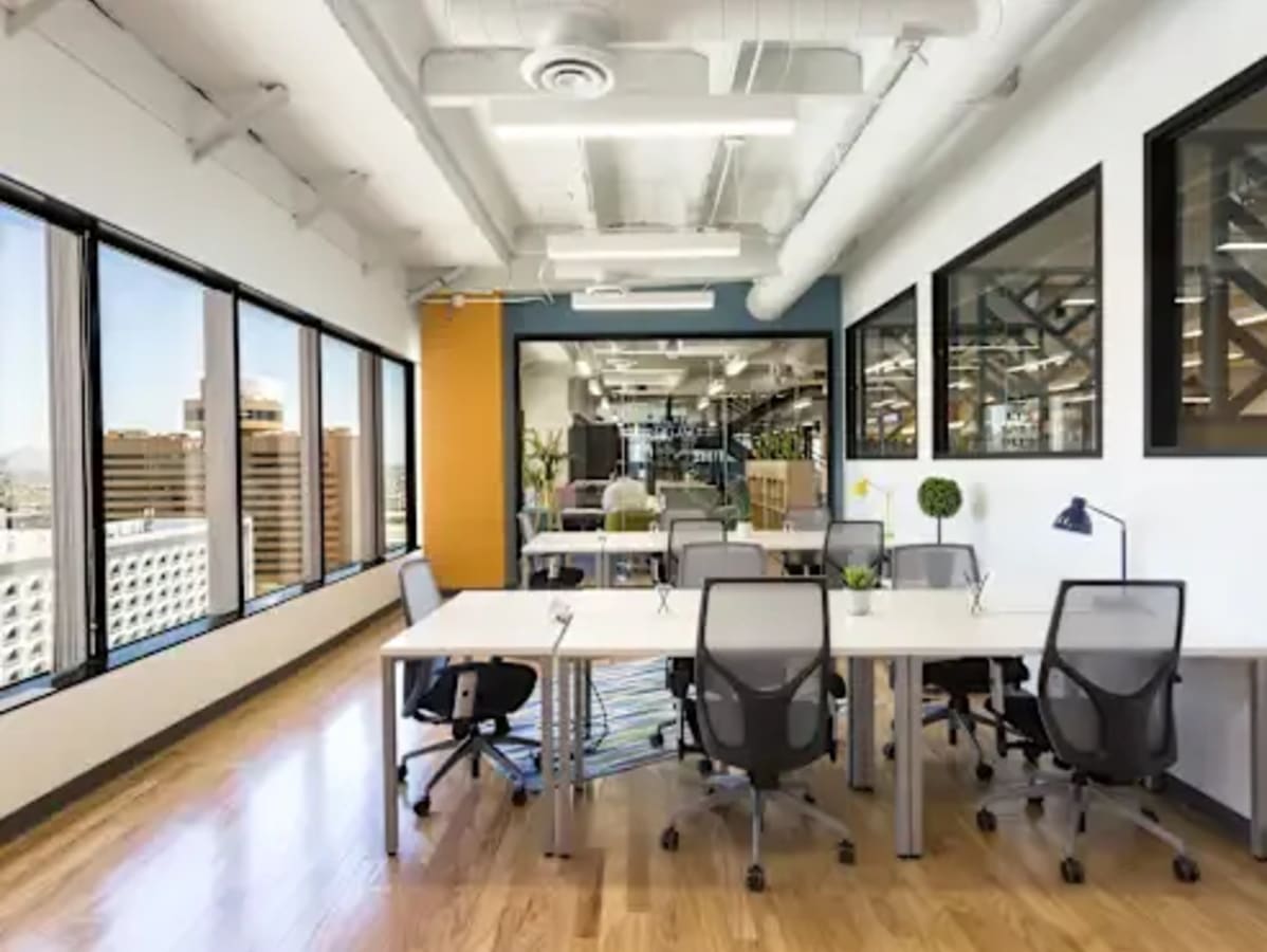 Bright coworking space with modern desks, ergonomic chairs, and large windows on Kamarajar Road.