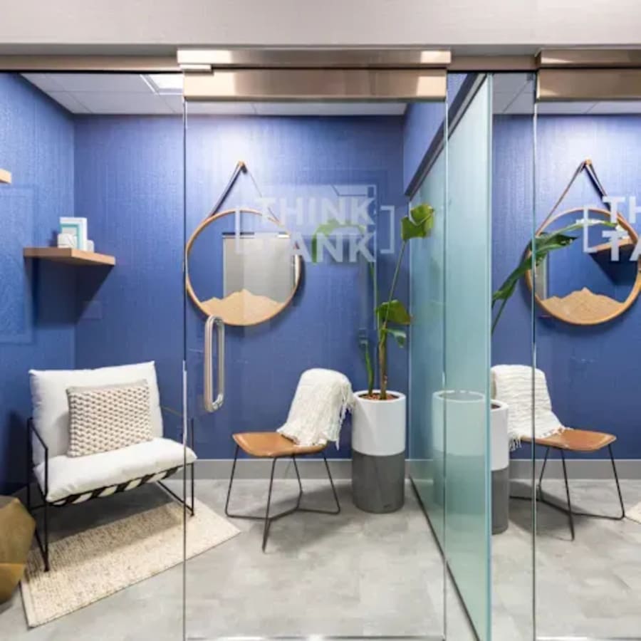 Modern coworking space with cozy chairs, stylish decor, and a calming blue palette.