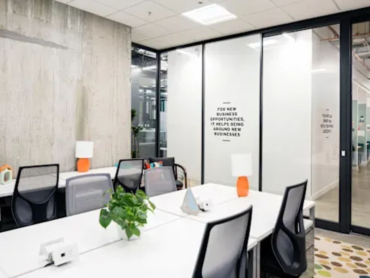 Modern coworking space with sleek desks, comfortable chairs, and natural light. Ideal for collaboration.