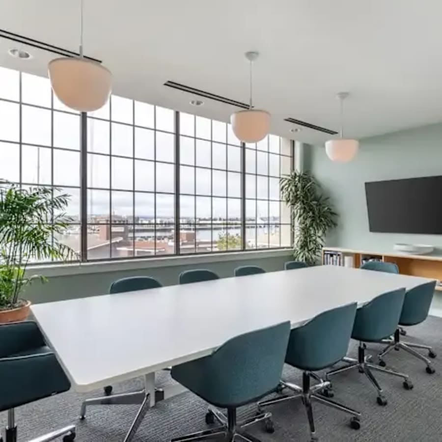Bright, modern meeting room with city views, ergonomic chairs, and sleek technology. Ideal for collaboration.