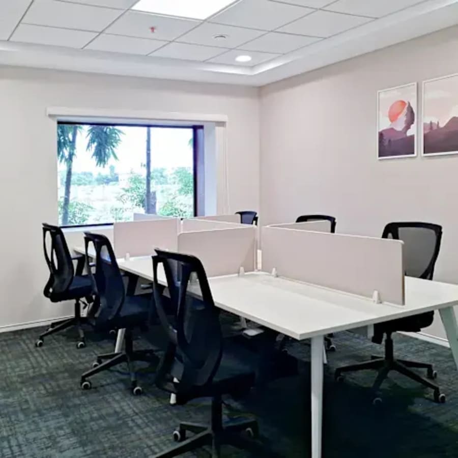 Modern coworking space with ergonomic desks and chairs, ample natural light, and serene views.