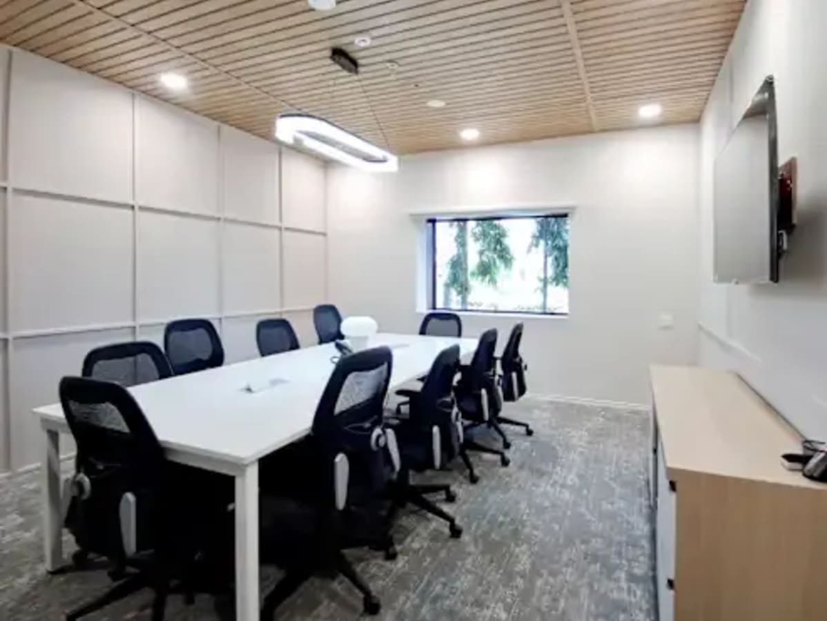 Modern coworking space with a sleek conference room, ergonomic chairs, and tech amenities.