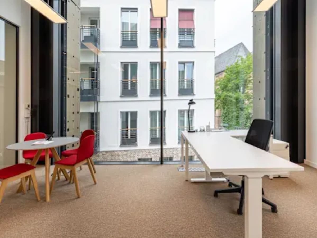 Bright coworking space with large windows, modern furnishings, and scenic views on Infopark Road.