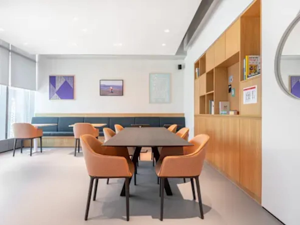 Bright coworking space with modern seating, ample natural light, and stylish artwork.