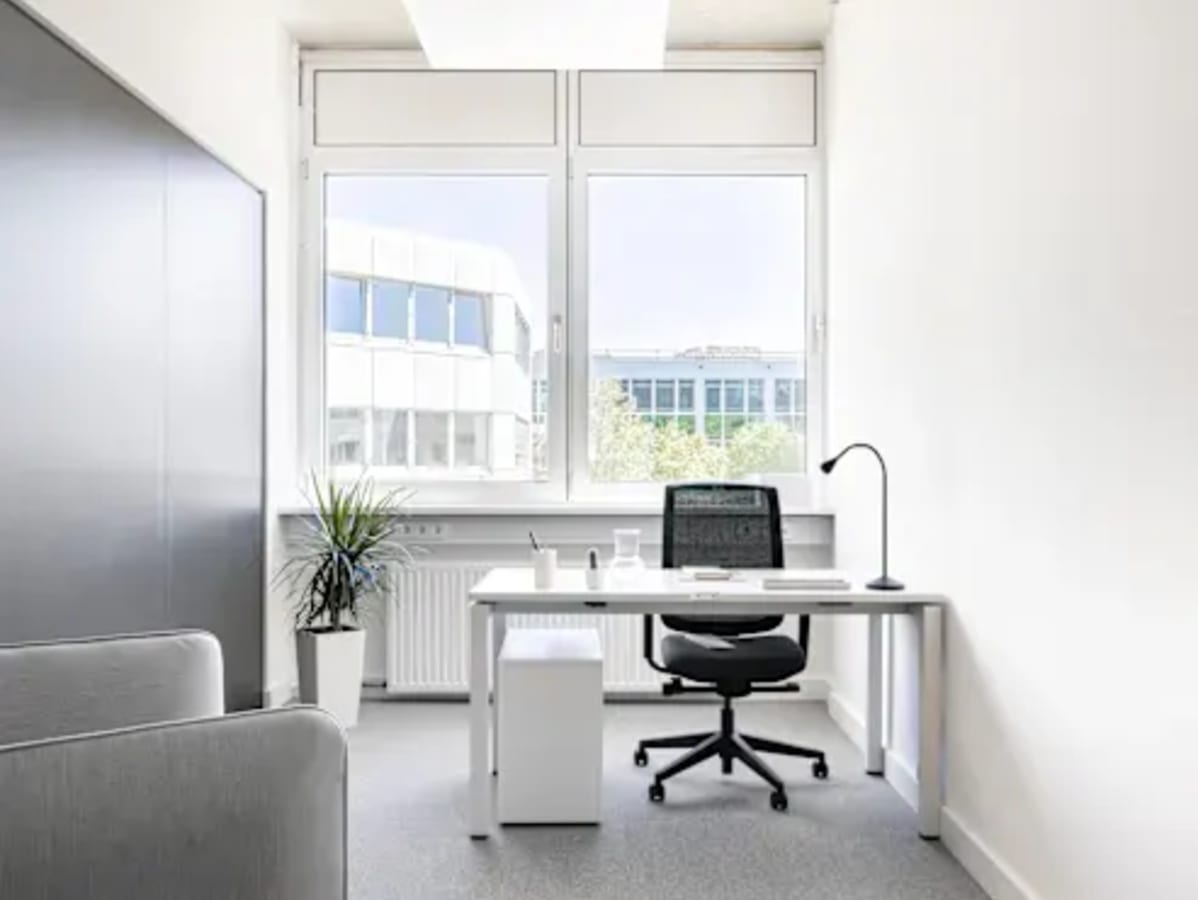 Bright and modern workspace with natural light, ergonomic chair, and sleek desk setup.