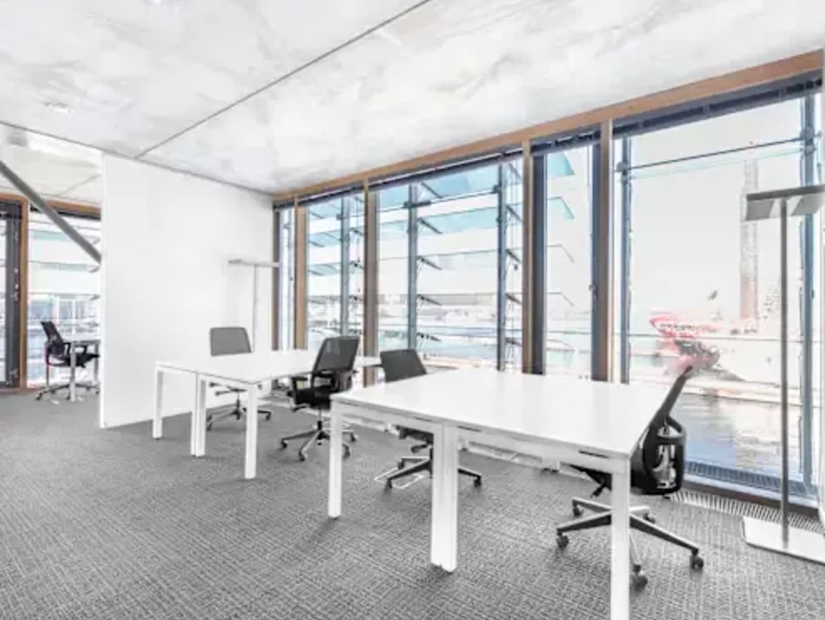Bright coworking space with modern desks and ergonomic chairs, overlooking scenic views.