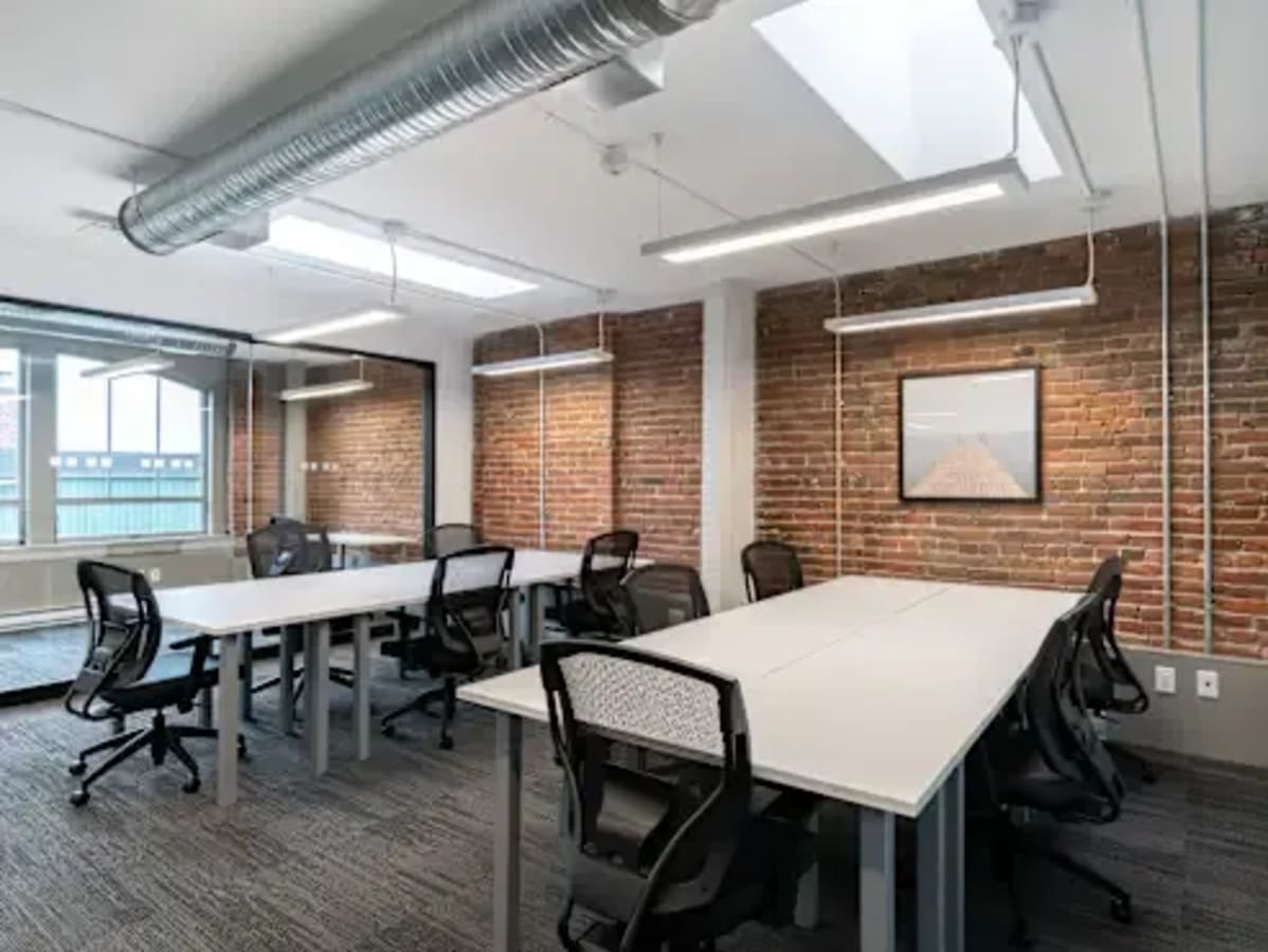Modern coworking space with exposed brick, natural light, and ergonomic seating in Navi Mumbai.