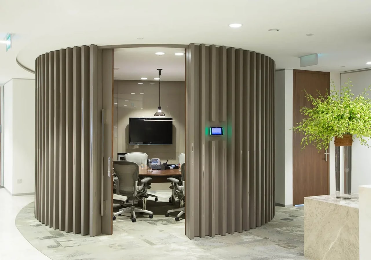 Stylish meeting pod with modern seating and screen, ideal for collaborative sessions.