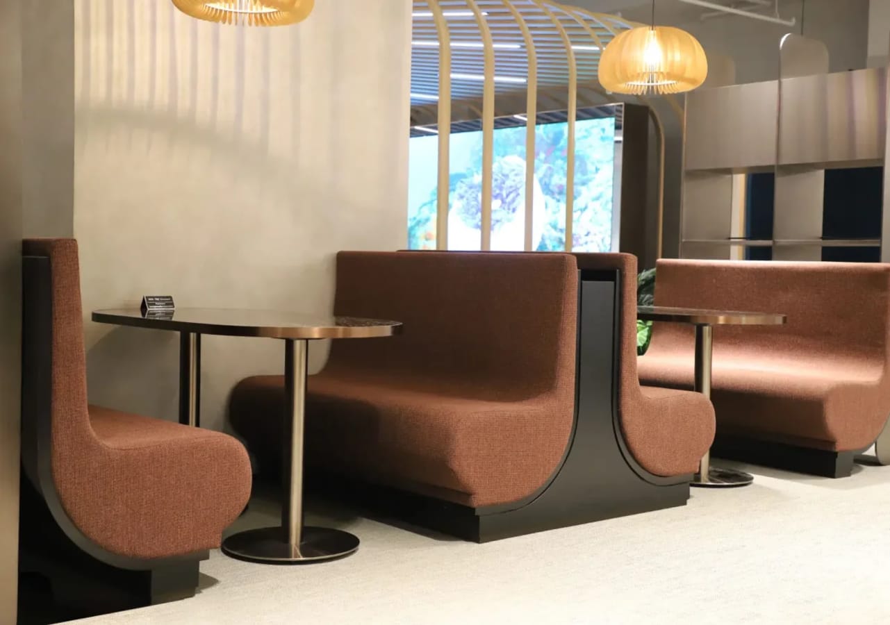 Modern coworking nook with plush seating and ambient lighting, ideal for collaboration.