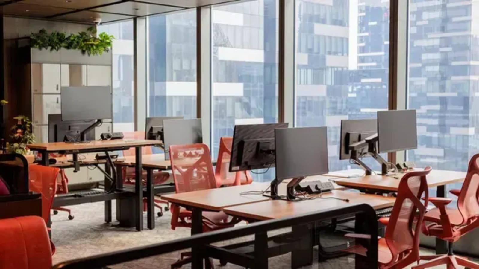 Bright coworking space with modern desks, ergonomic chairs, and city views. Ideal for collaboration.