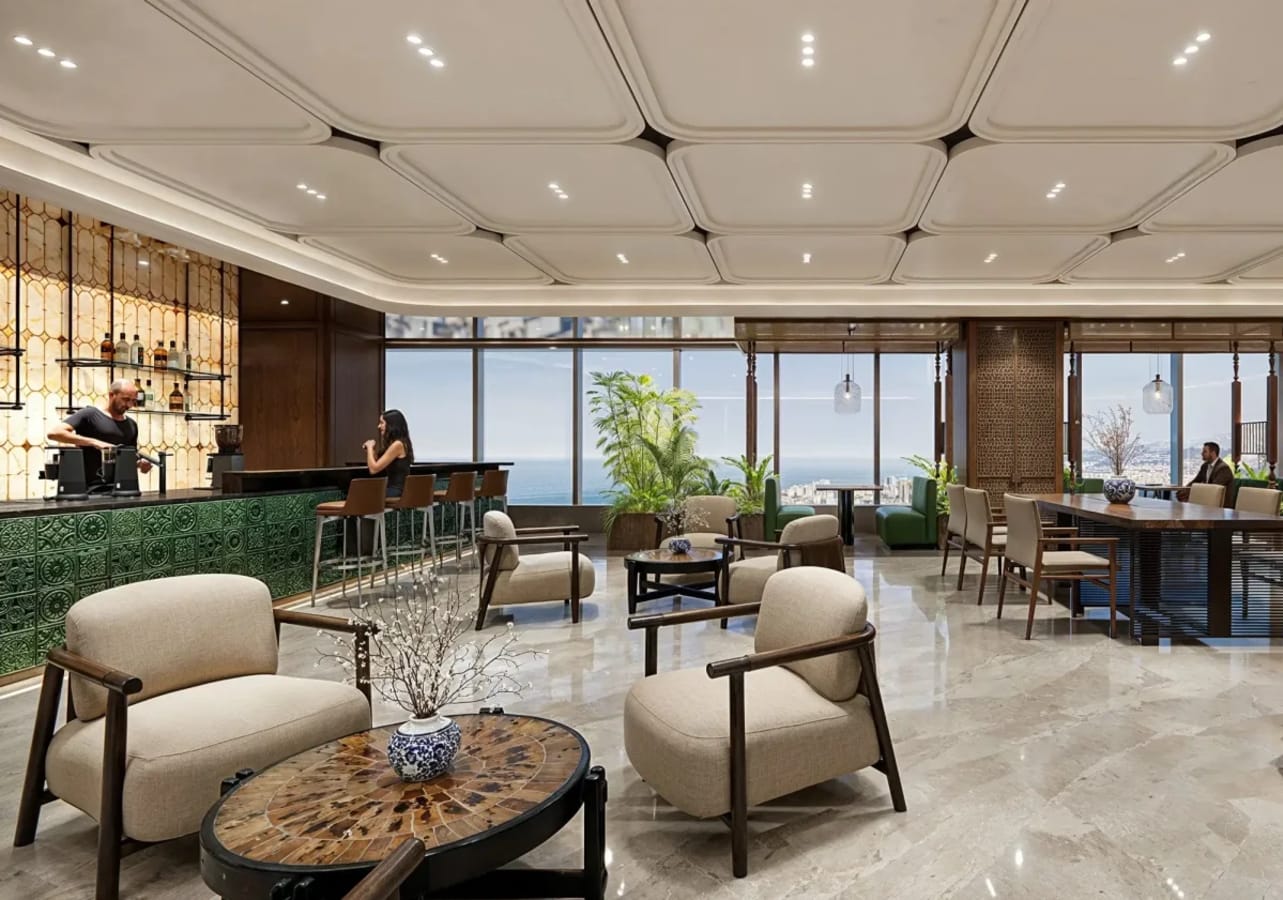 Sleek coworking space with ocean views, stylish seating, and a vibrant bar area. Ideal for collaboration.