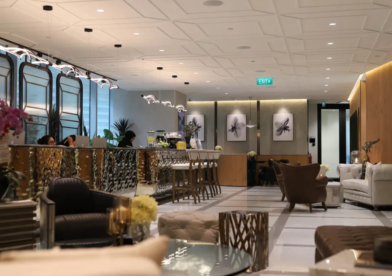 Elegant coworking lounge with stylish seating and a sleek, modern bar for a productive ambiance.