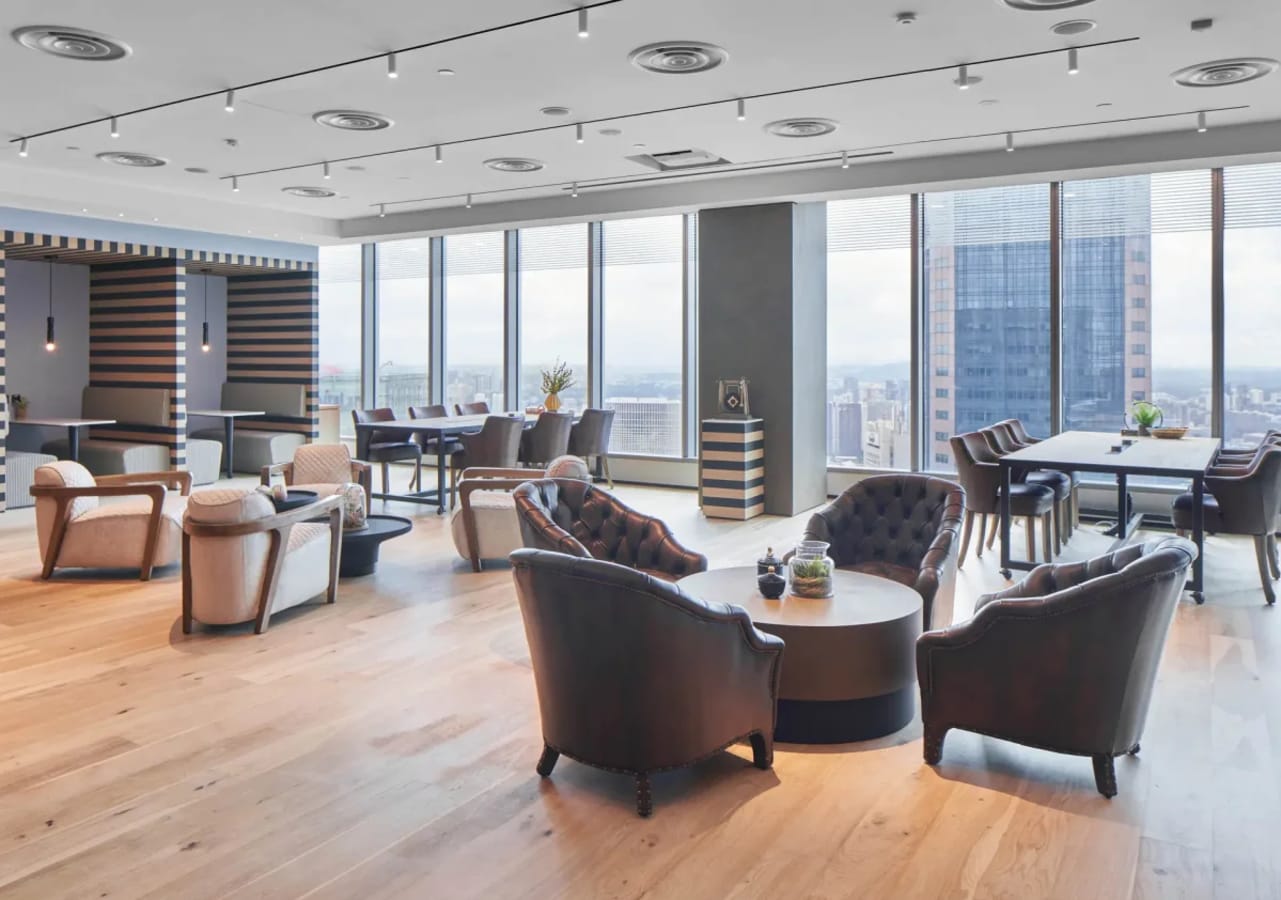 Sleek coworking space with city views, modern furnishings, and inviting natural light.