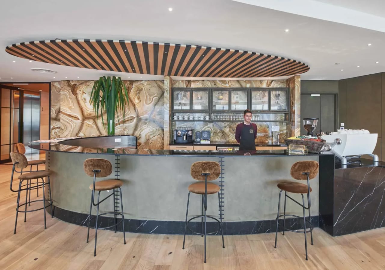 Stylish coworking café area with modern bar seating and artistic design accents.