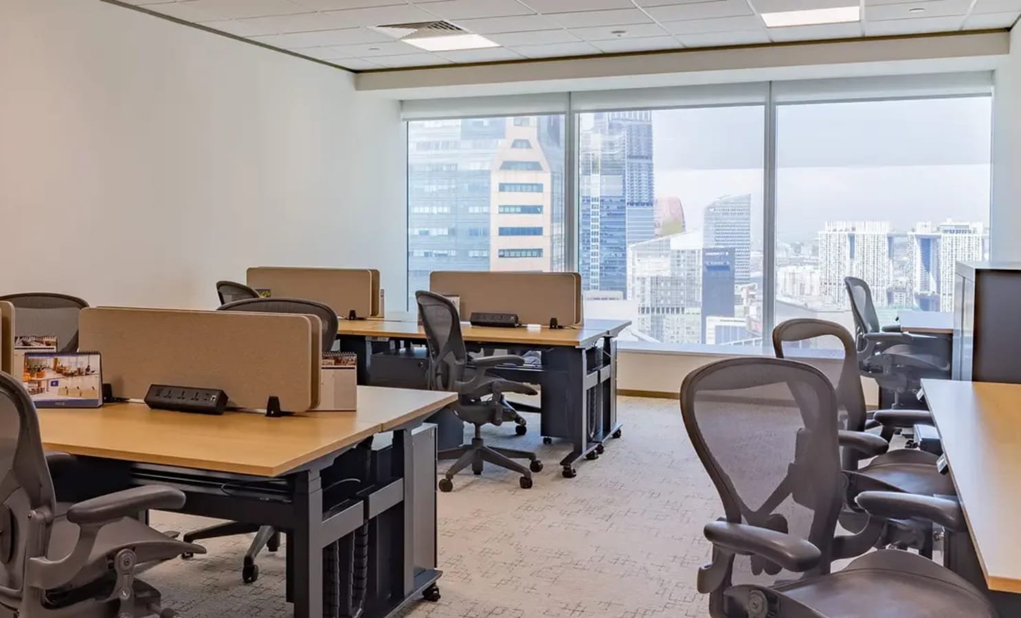 Spacious coworking area with modern desks and panoramic city views, perfect for dynamic teams.