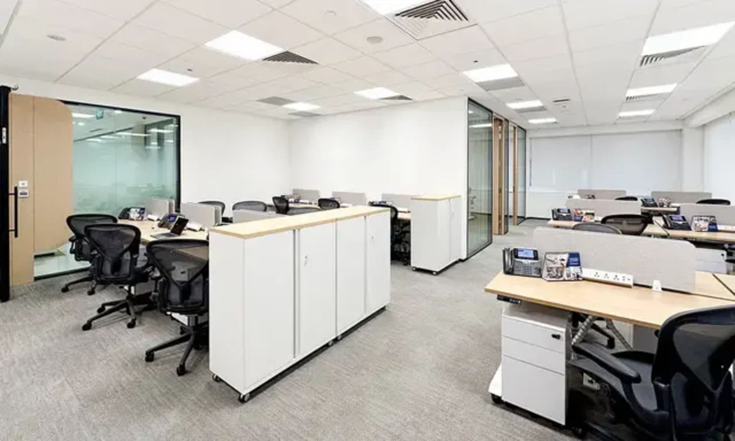 Modern coworking space with open desks, natural light, and sleek furnishings in Raffles Place.