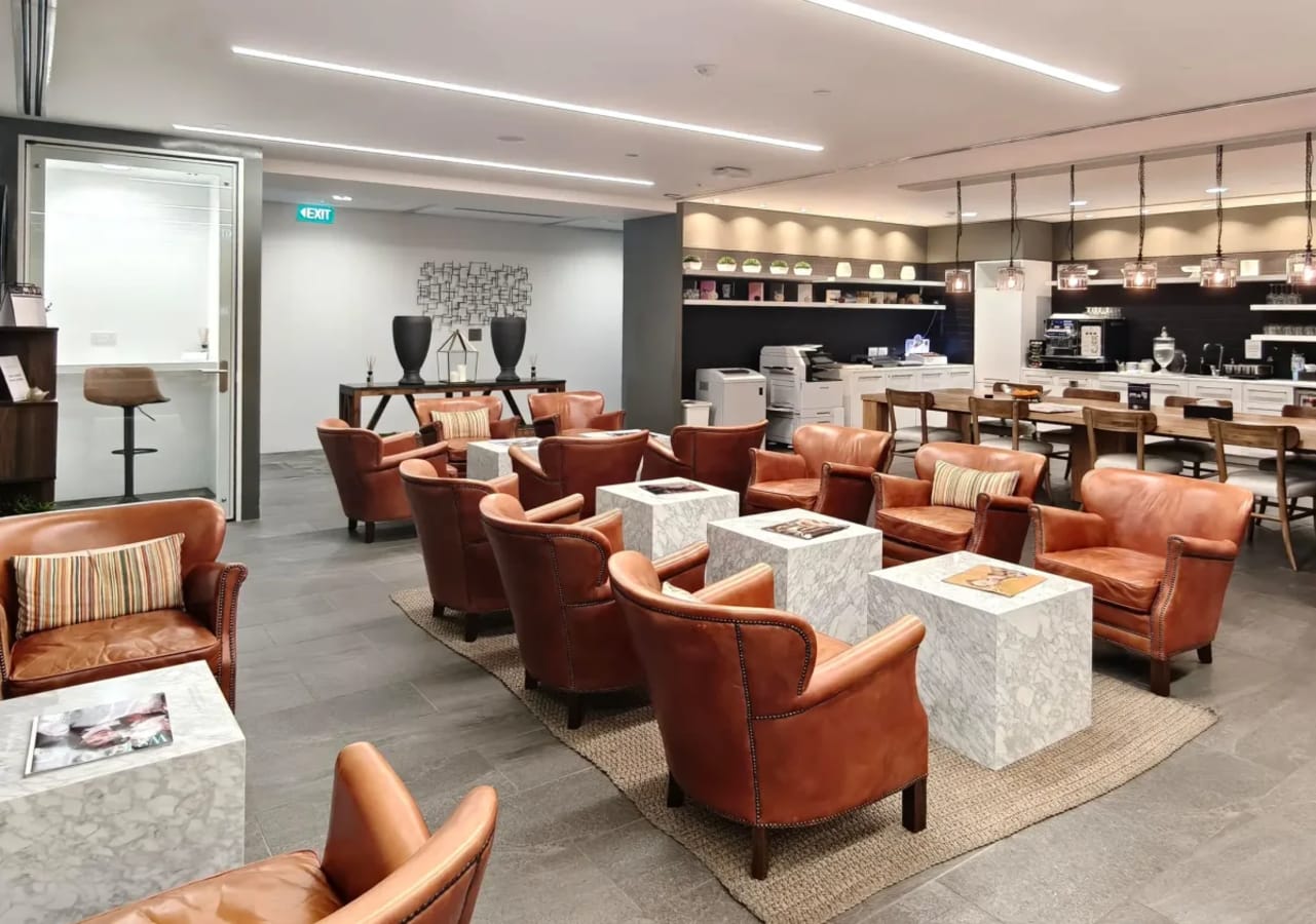 Cozy coworking space with plush leather seating, modern lighting, and a well-equipped pantry area.
