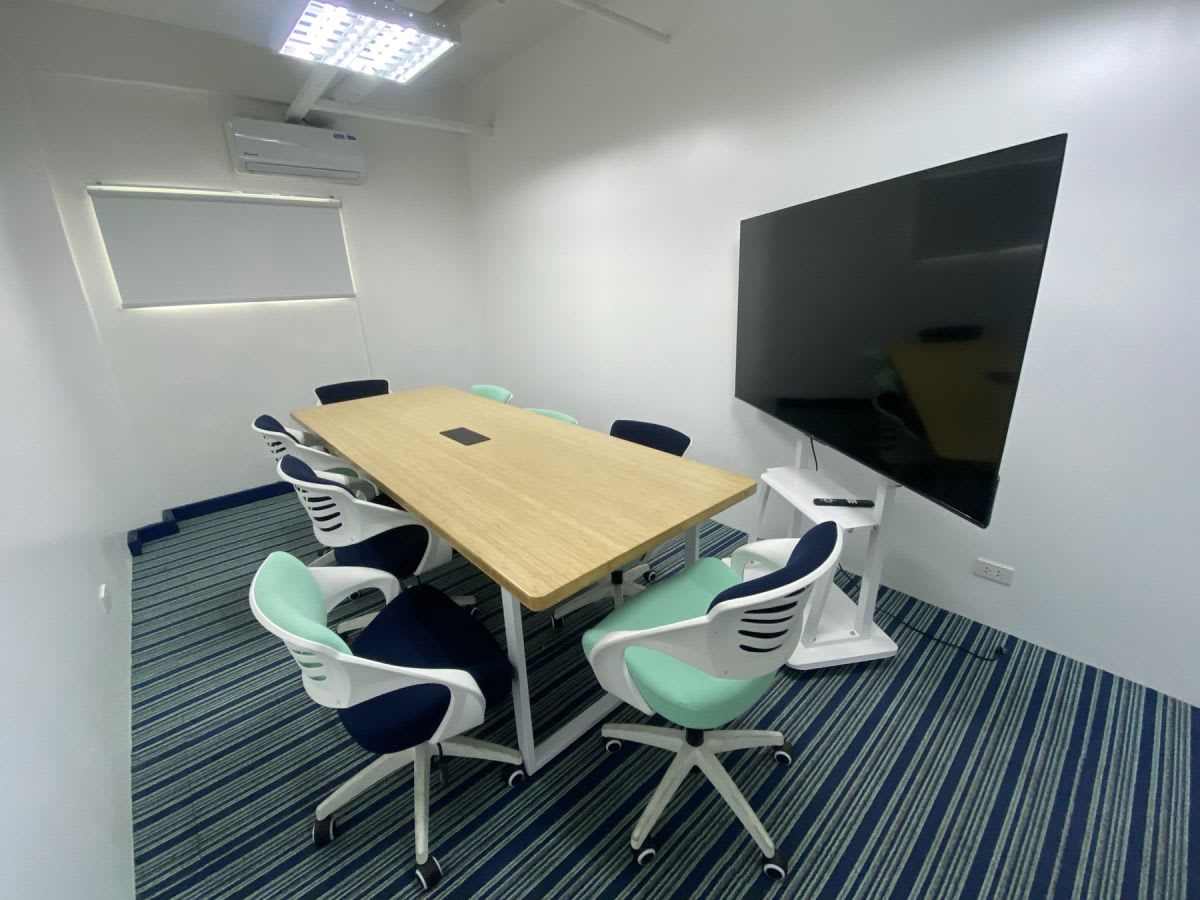 Modern meeting room with ergonomic chairs, large screen, and natural light in Angel St coworking space.
