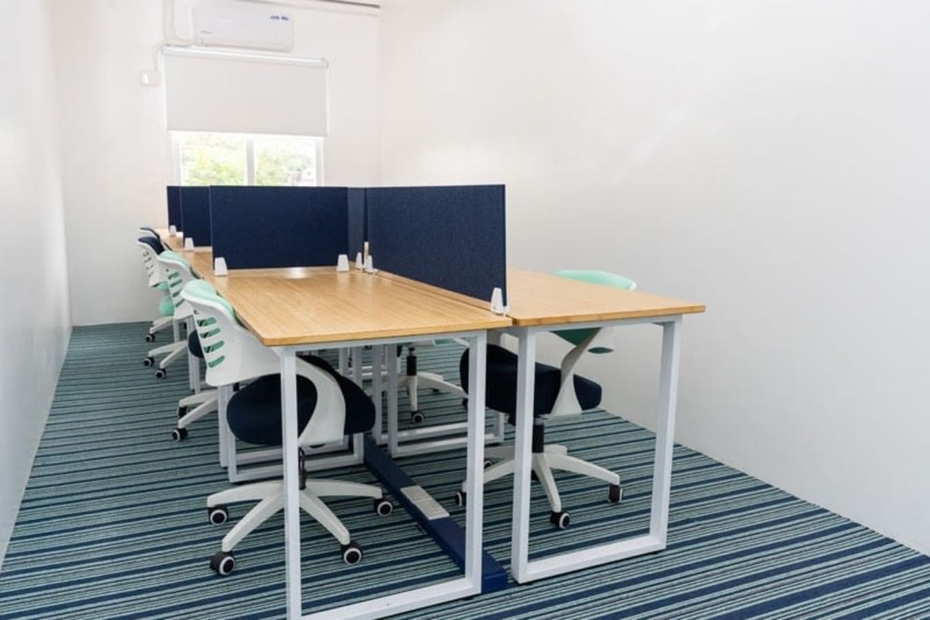 Modern coworking space with shared desks, ergonomic chairs, and abundant natural light.