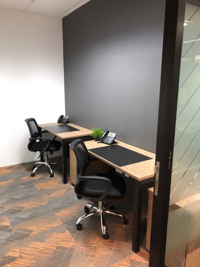 Modern coworking desk setup with ergonomic chairs and sleek design in Singapore.