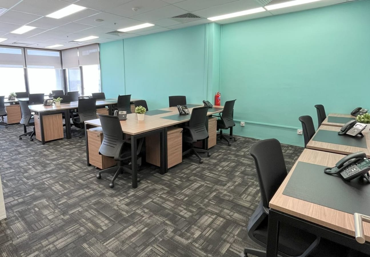 Modern coworking space with spacious desks, ergonomic chairs, and ample natural light.