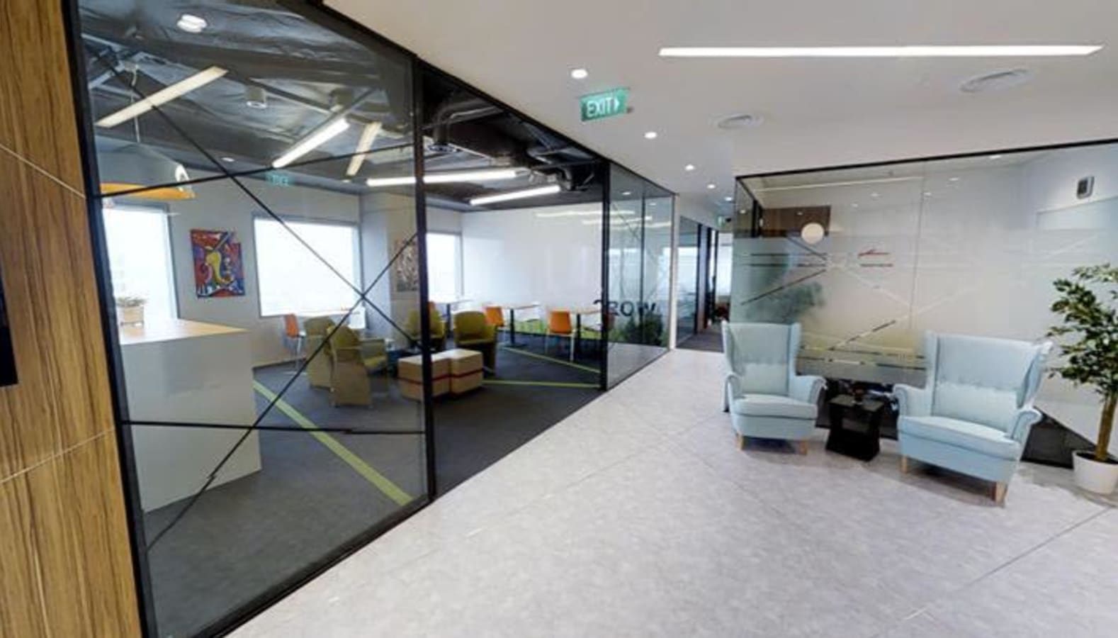 Modern coworking space with sleek glass walls, comfy seating, and natural lighting in Temasek Boulevard.