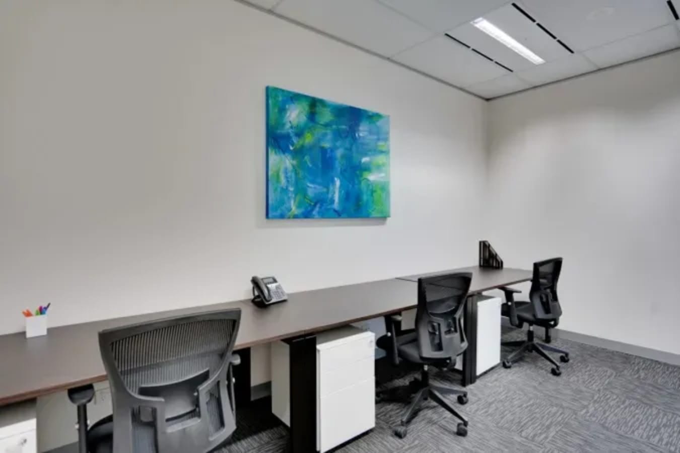 Modern coworking space with executive chairs, ample desk space, and vibrant art in Gangnam.