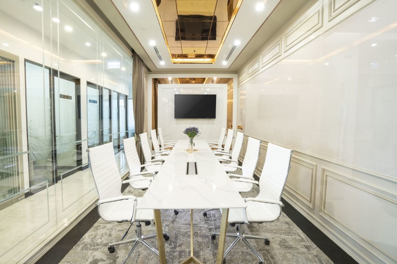 Elegant boardroom with sleek white chairs, modern table, and integrated AV setup. Perfect for meetings.