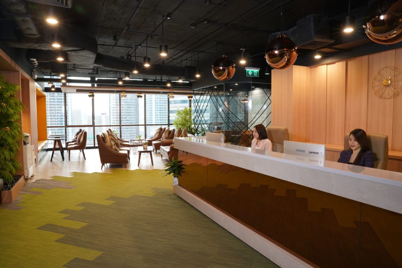 Modern coworking space with ample natural light, vibrant decor, and a welcoming reception.