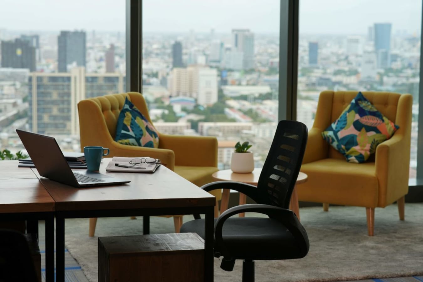Bright coworking space with city views, modern furniture, and vibrant decor. Ideal for productivity.