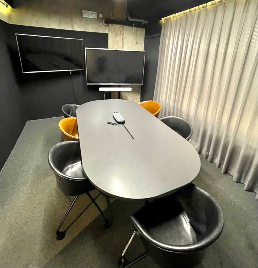 Sleek meeting space with modern seating, dual screens, and ambient lighting in Chai Wan Kok.