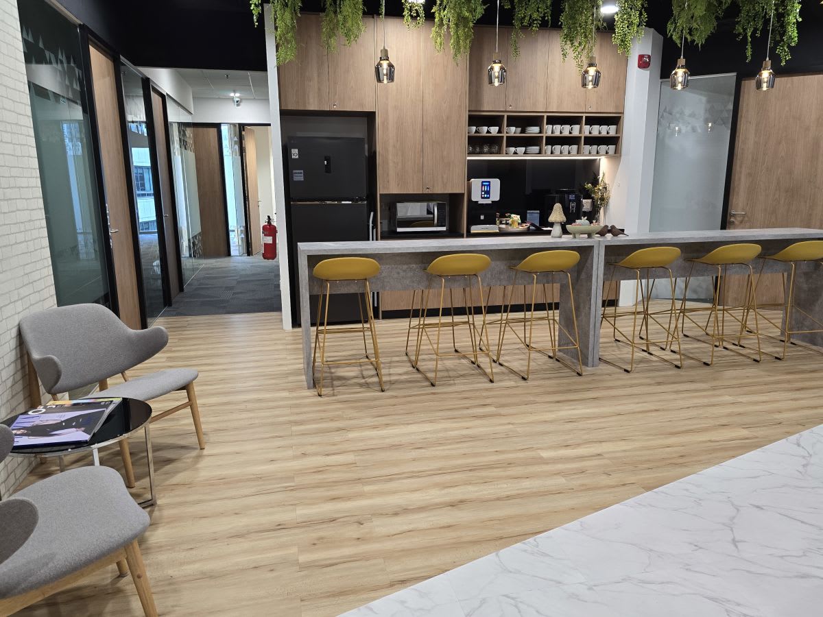 Modern coworking kitchen with ample seating and sleek design in central Singapore.