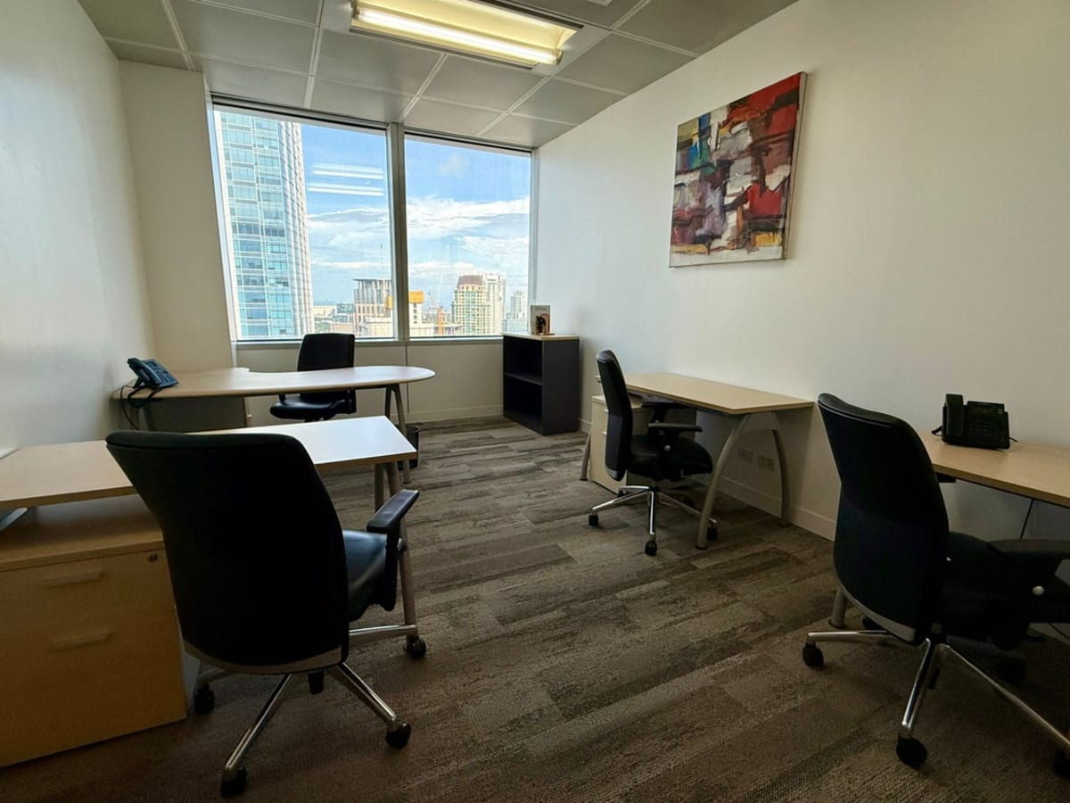 Modern coworking space with a city view, ergonomic chairs, and natural lighting.