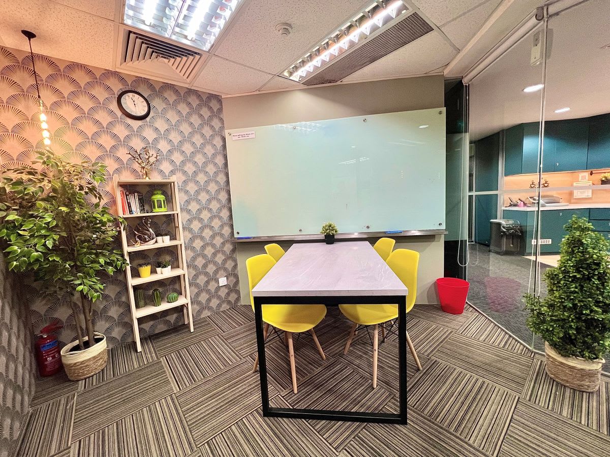 Bright, flexible space with vibrant seating, a whiteboard, and glass walls in Cecil Street coworking hub.