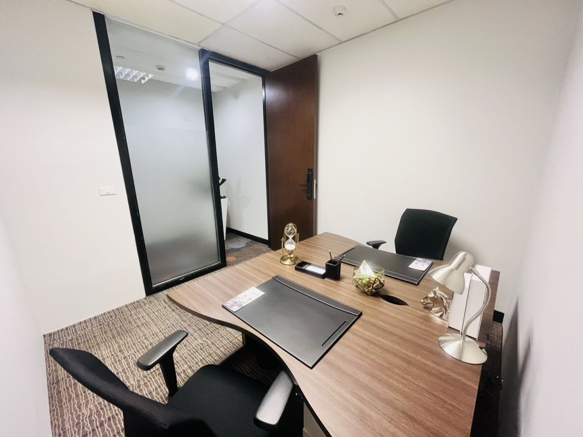Modern private office with sleek furniture, ample lighting, and frosted privacy glass.