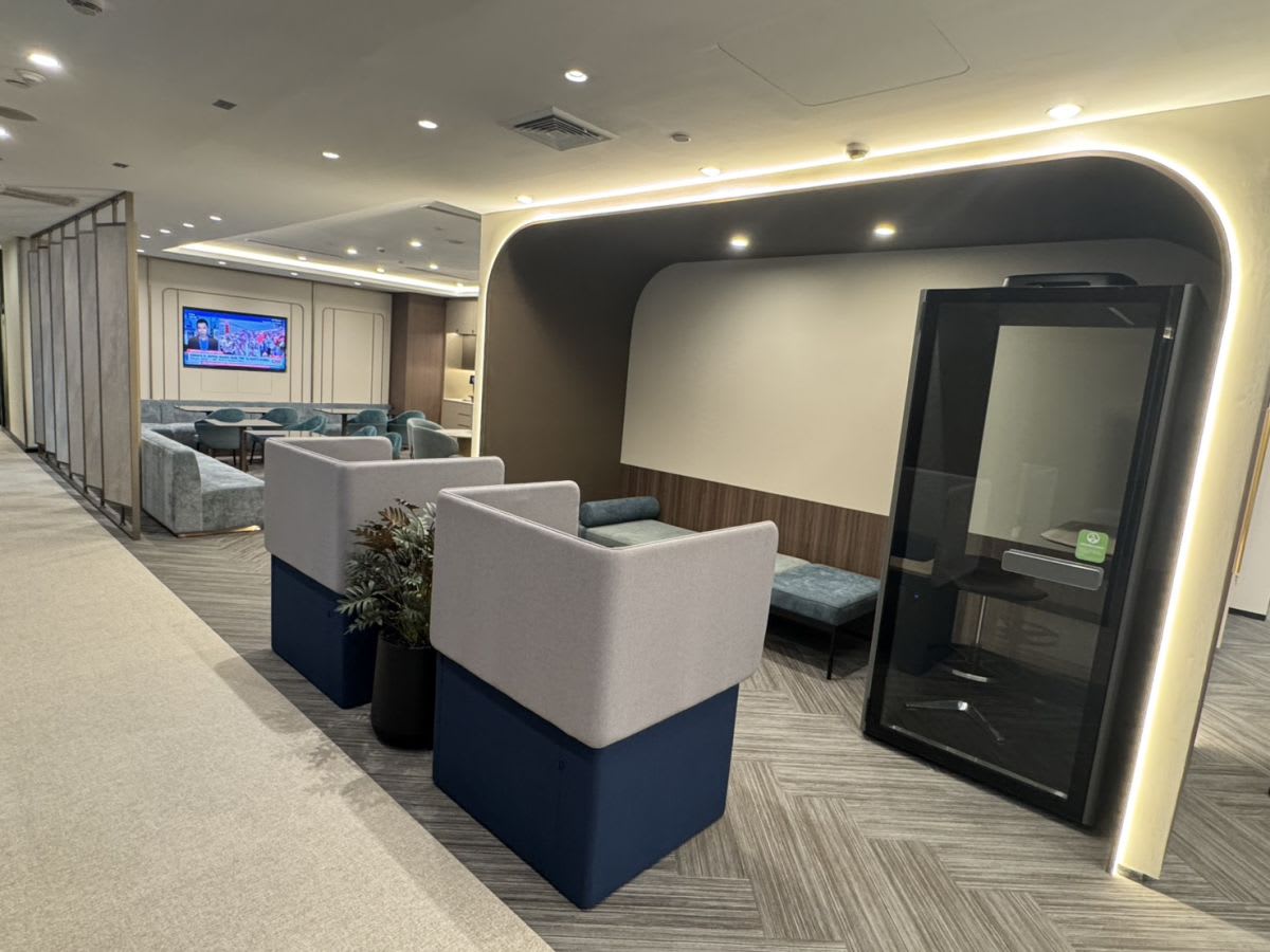 Modern coworking space with cozy seating, private booth, and stylish lighting. Ideal for meetings.