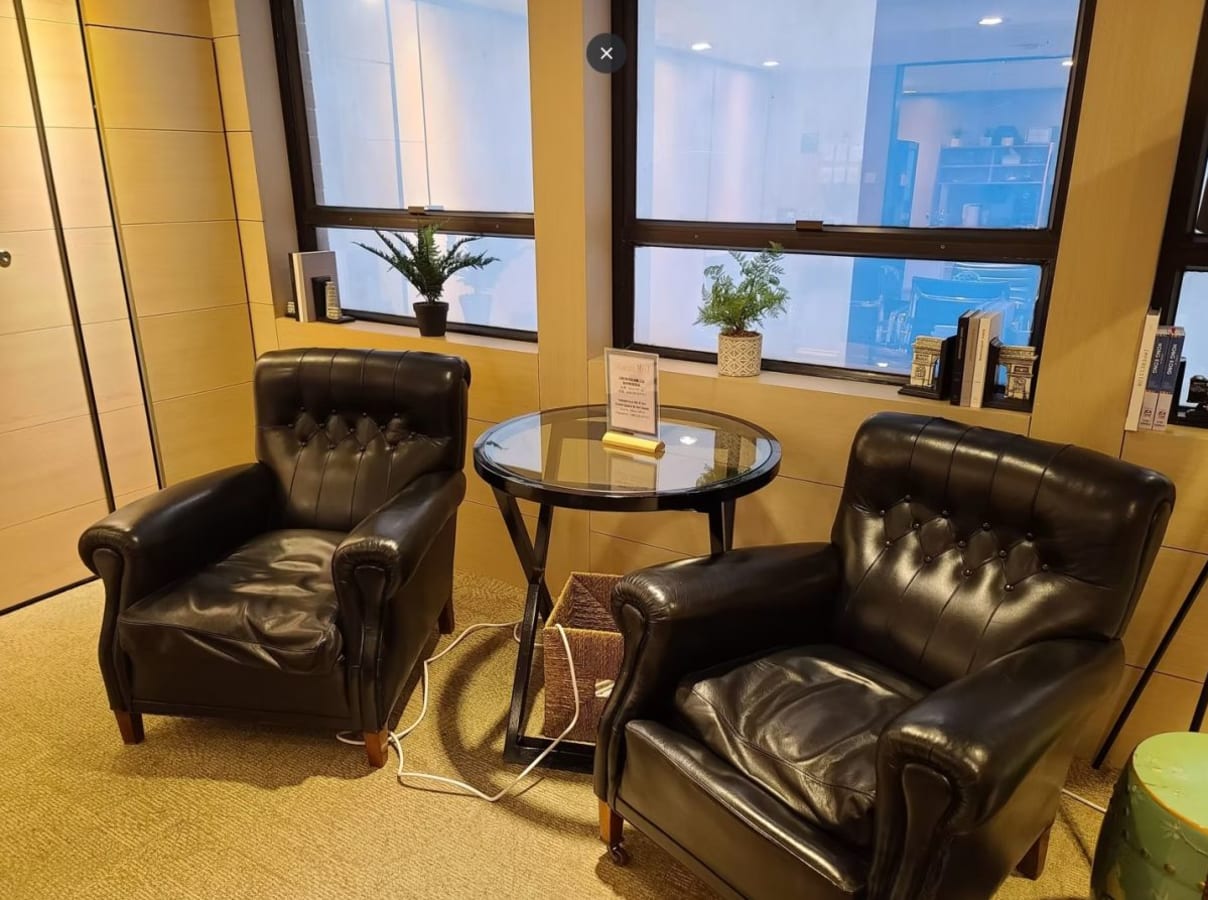 Cozy breakout area with leather chairs and natural light, perfect for casual meetings.