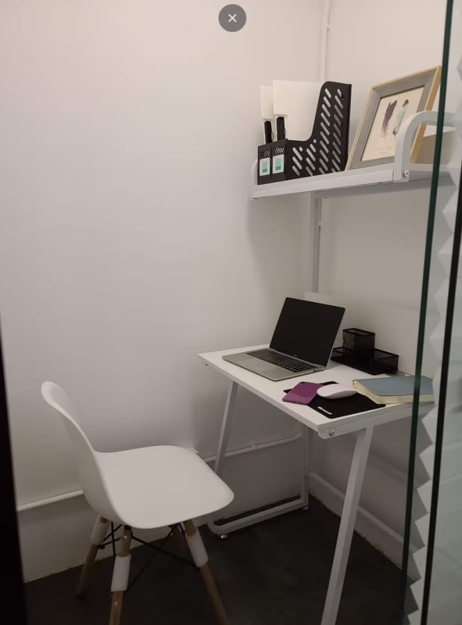 Compact and private workspace with modern desk, chair, and shelving in a flexible Hong Kong office.