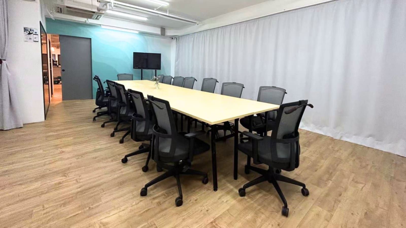 Modern conference room with ample seating and natural lighting, perfect for meetings.