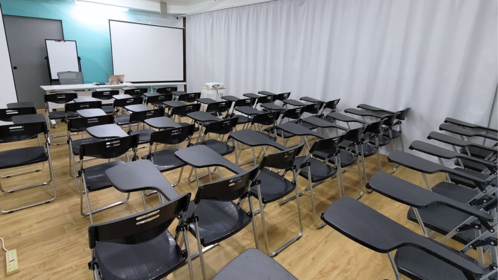 Spacious seminar room with ergonomic chairs, projector, and whiteboard. Ideal for workshops and presentations.
