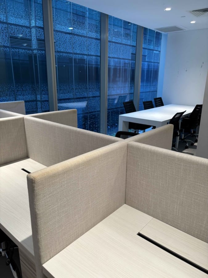 Bright coworking space with private booths and a sleek meeting room. Ideal for productivity.