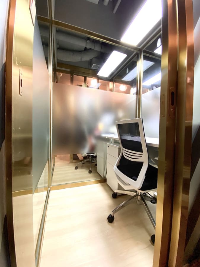 Modern, well-lit private office with sleek design, ergonomic chair, and frosted glass for privacy.