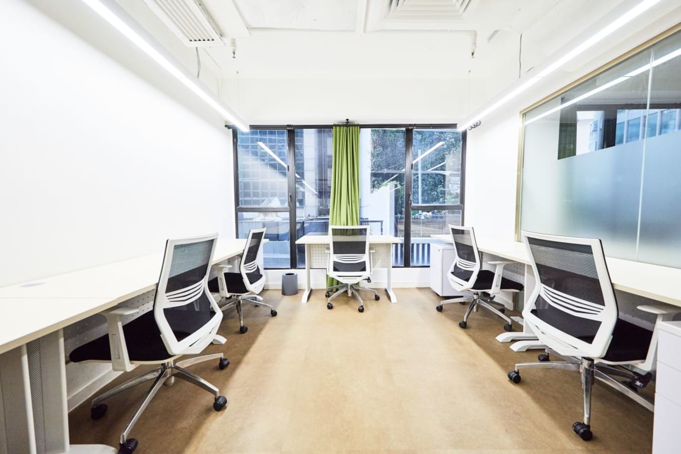 Bright and modern coworking space with ergonomic chairs and large windows in Central.