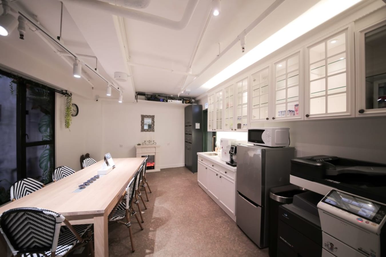 Modern coworking space with sleek kitchen amenities and collaborative seating. Ideal for meetings.