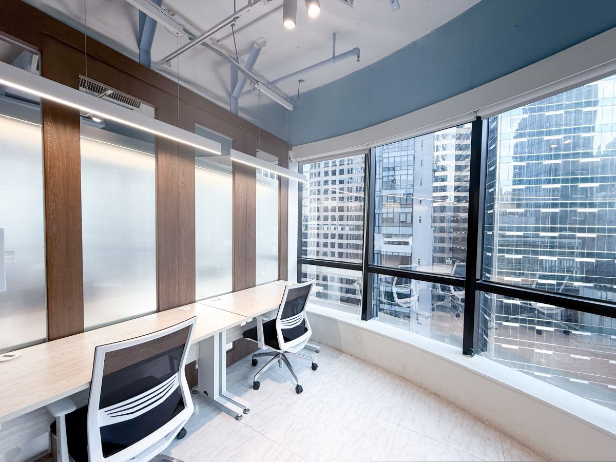 Bright coworking space with city views, ergonomic chairs, and sleek workstations on Wellington Street.