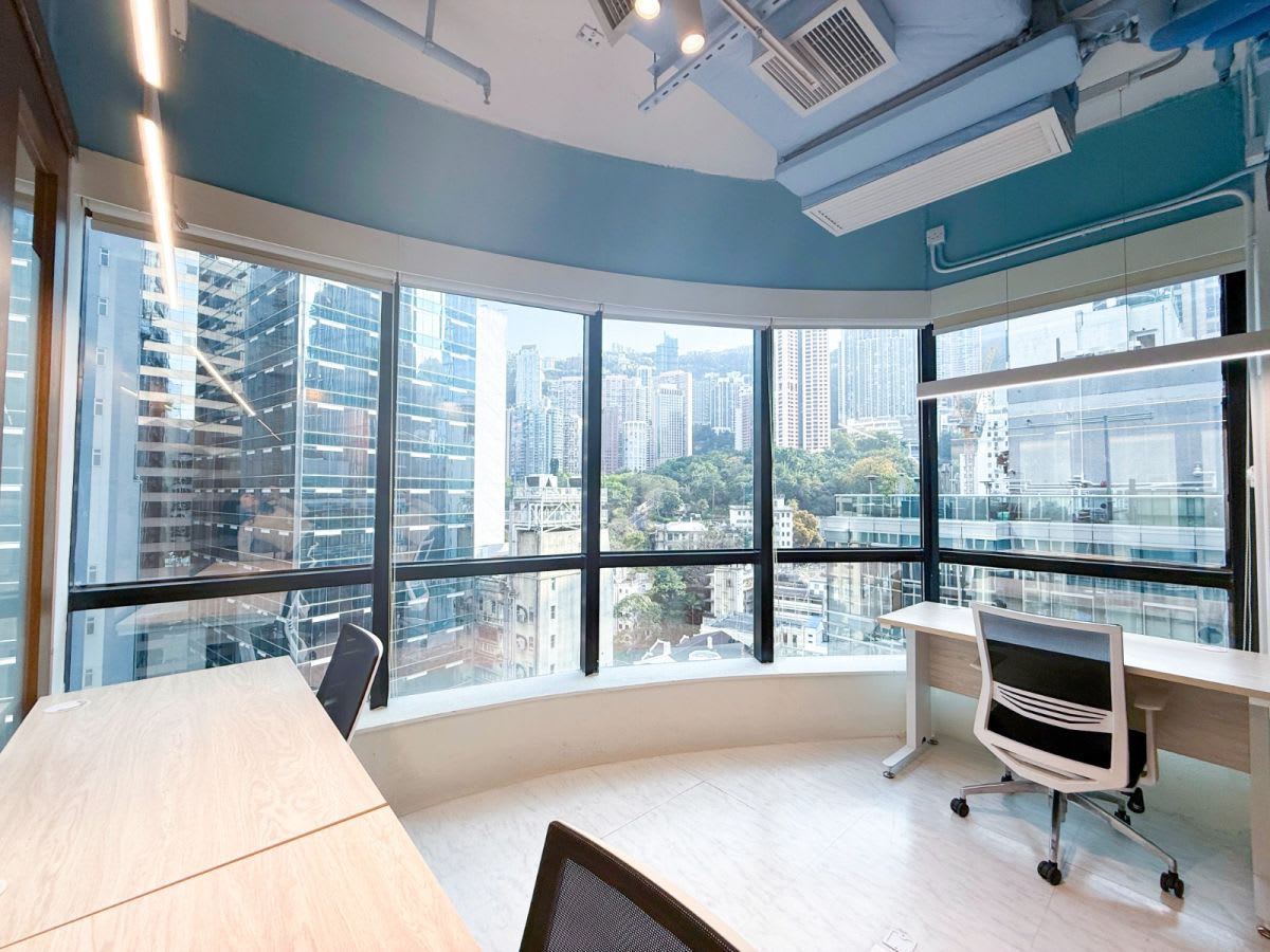 Bright coworking space with stunning city views, modern furniture, and ample natural light.