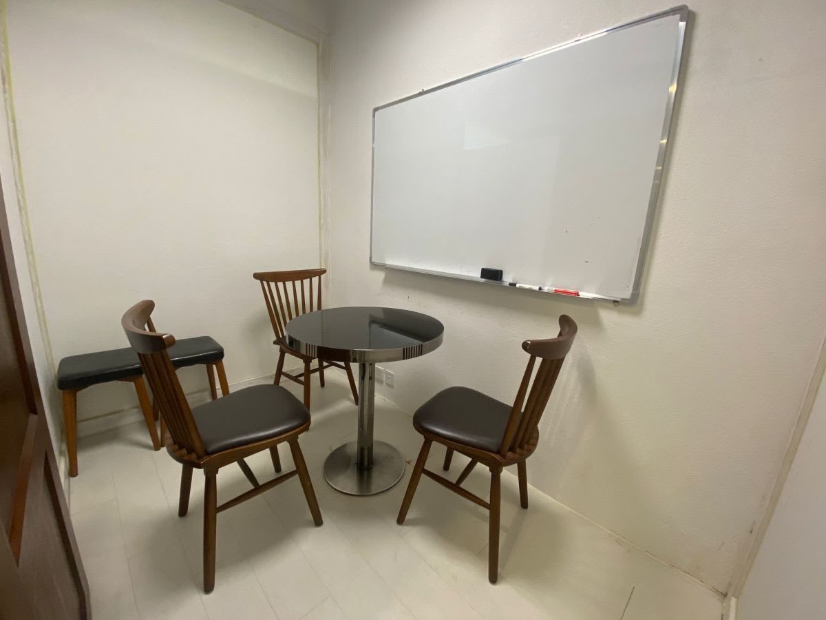 Cozy meeting room with whiteboard and seating for four, ideal for collaborative sessions.